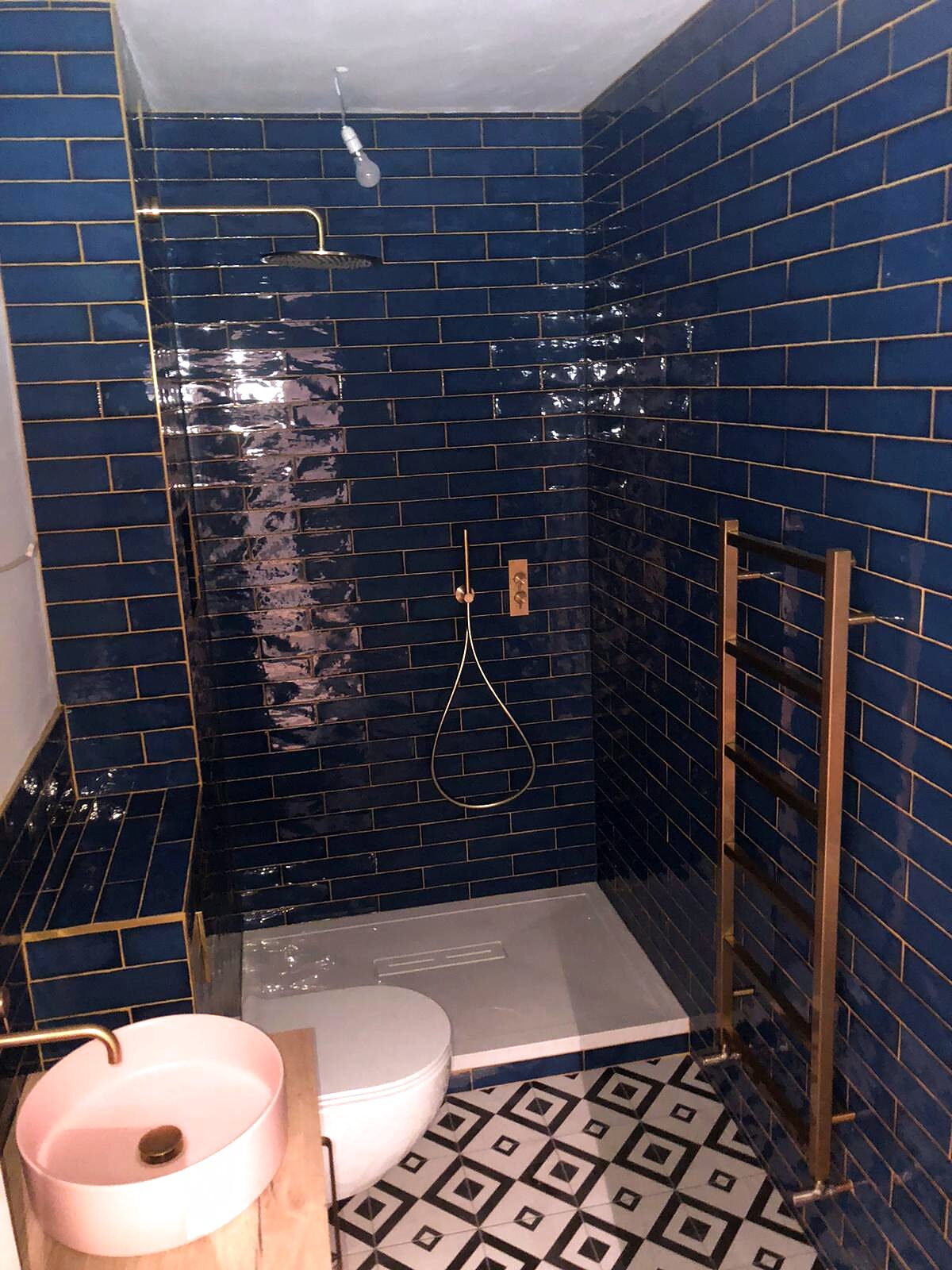 Deep blue metro tiles with brass fittings and a walk-in shower