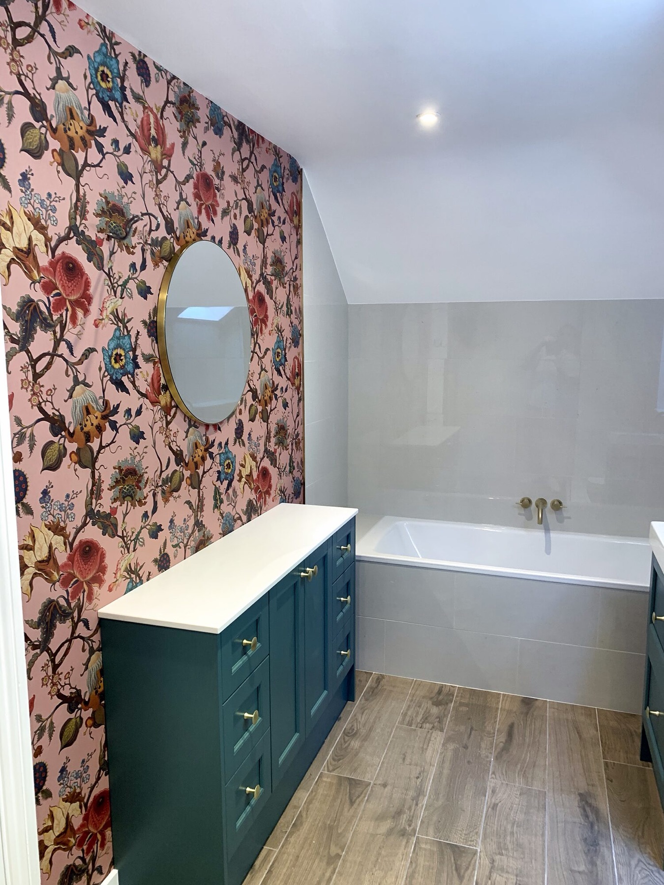 Floral wallpaper bathroom with a green vanity